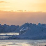 The sun setting over the UNESCO icefjord in Ilulissat, Greenland.