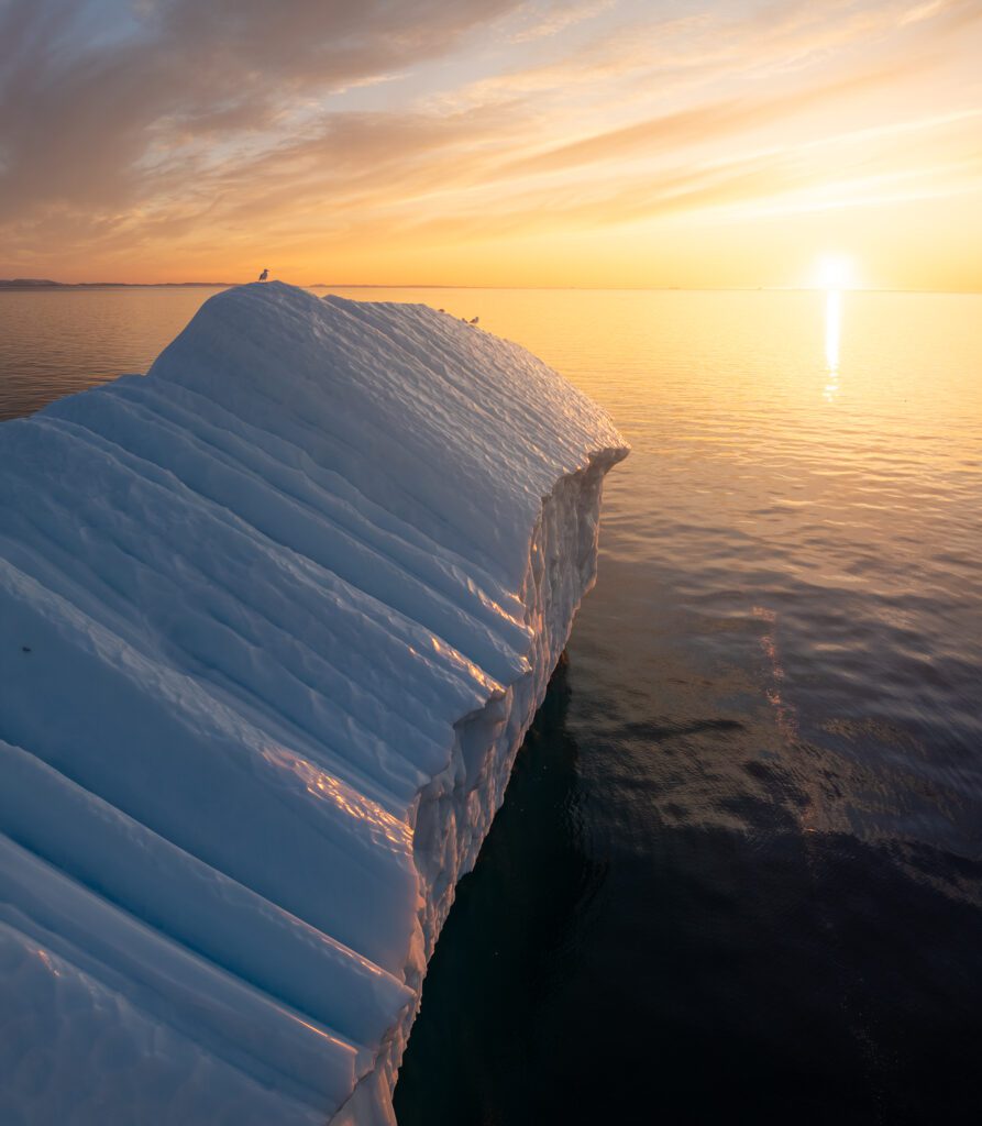 A drone shot of an iceberg near a small village in Greenland