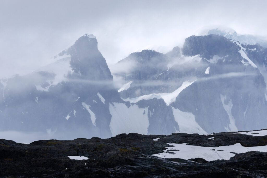 Fog dissipating over very tall mountains on the Antarctic Peninsula